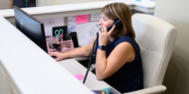 Dental receptionist dealing with an enquiry